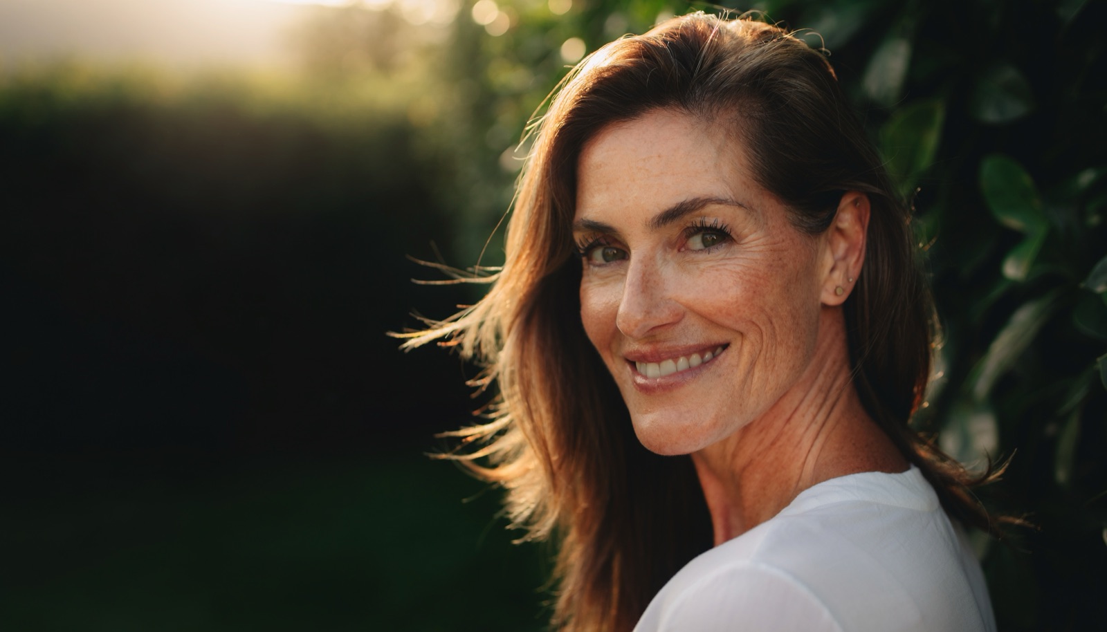 Woman smiling outdoors in golden evening light